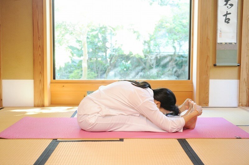 両手でつま先をつかみ、深く前屈する